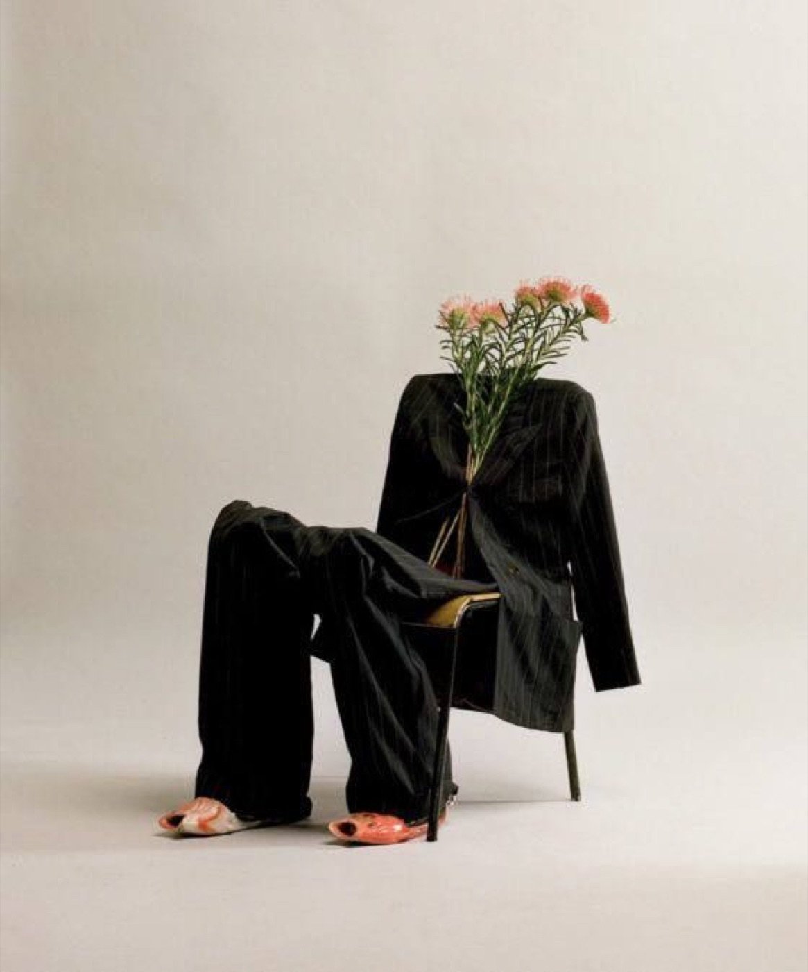 Suit on a chair holding flowers, studio still life